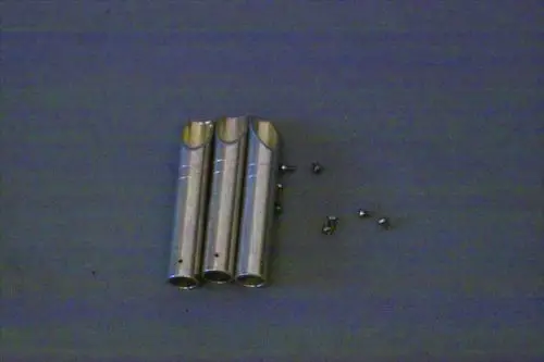 Brötje Produkt mit drei metallischen Rohren und mehreren kleinen Schrauben, auf einer neutralen Oberfläche angeordnet.