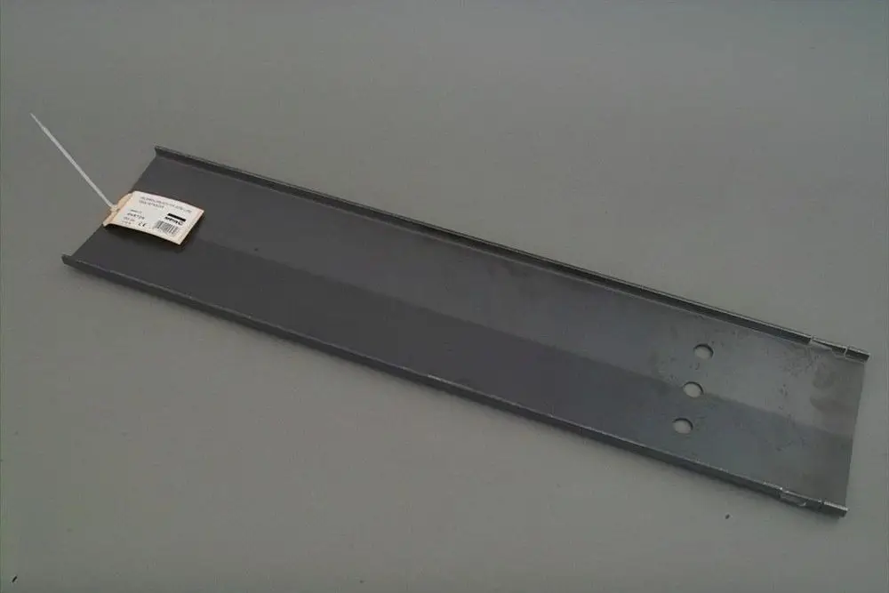Brötje Metallblech in rechteckiger Form, mit zwei Löchern an einer Seite und einem Etikett, auf grauem Hintergrund liegend.