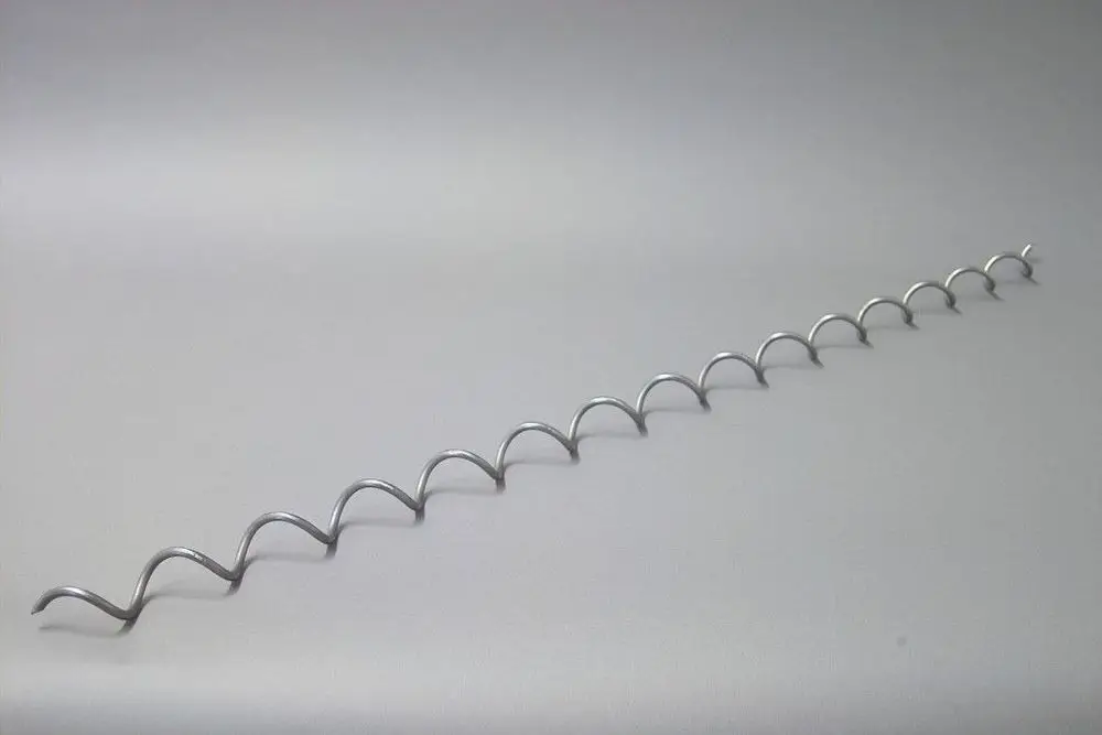 Brötje Wirbulator in gewellter Form, aus Metall, auf hellgrauem Hintergrund, mit gleichmäßigen Wellen und einer durchgehenden Linie.
