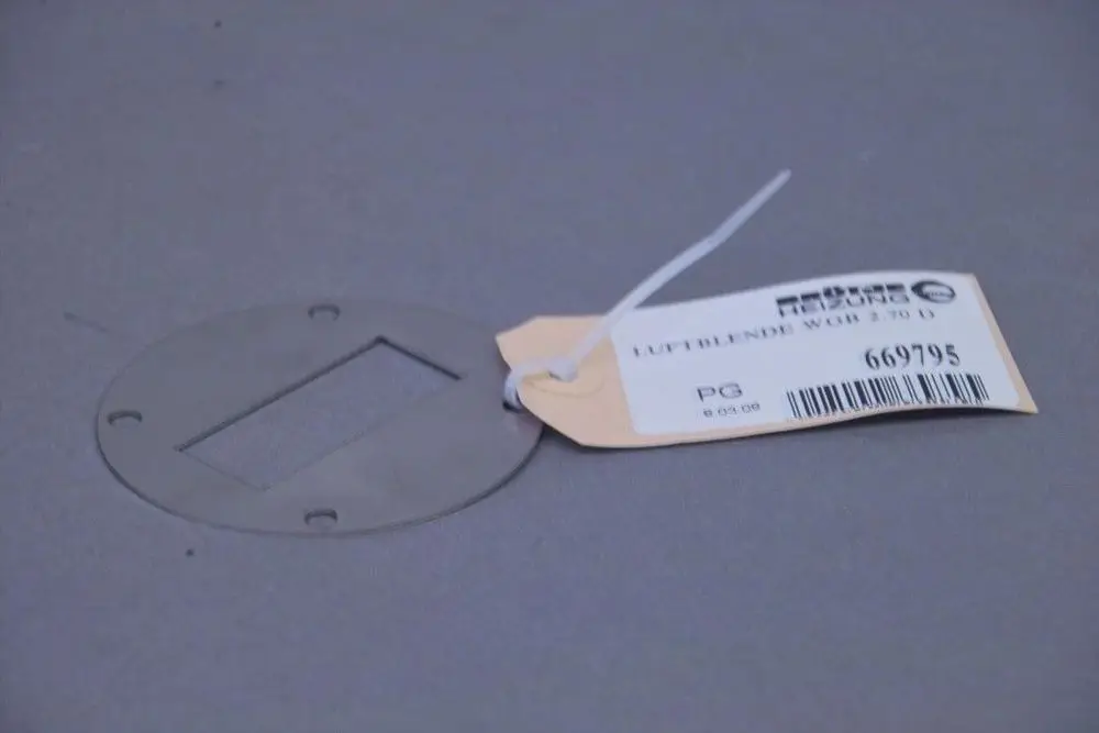 Metallplatte mit rechteckigem Ausschnitt und vier Befestigungslöchern, beschriftet mit einer Produktinformation von Brötje, auf grauem Hintergrund.