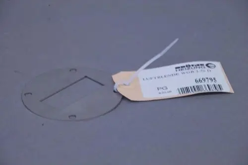 Metallplatte mit rechteckigem Ausschnitt und vier Befestigungslöchern, beschriftet mit einer Produktinformation von Brötje, auf grauem Hintergrund.