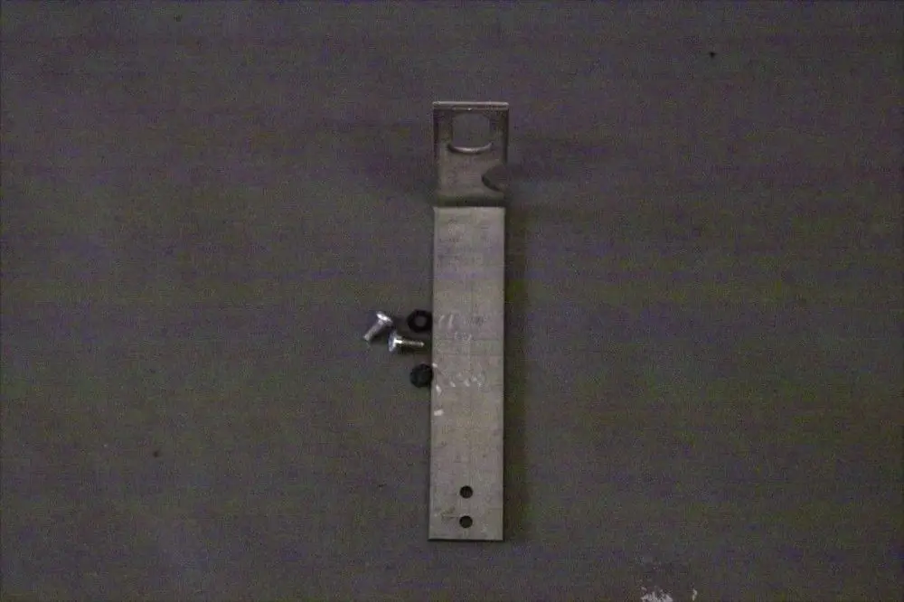 Brötje Halter aus Metall, langgestreckt mit einer Aussparung und mehreren Löchern für die Montage. Im Bild sind auch Schrauben und Unterlegscheiben zu sehen.
