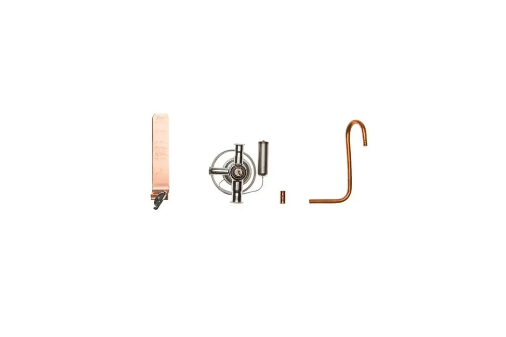 Verschiedene Metallteile, darunter eine Kupferröhre und ein Gerät mit einem Drehmechanismus, präsentiert in einem weißen Hintergrund, möglicherweise für ein Brötje Produkt.