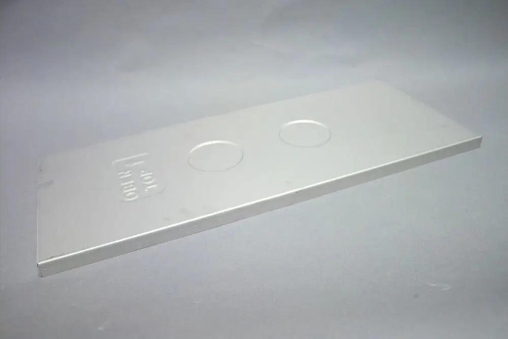 Brötje Gehäusedeckel aus Metall, flach und rechteckig mit zwei kreisförmigen Ausschnitten, auf grauem Hintergrund platziert.
