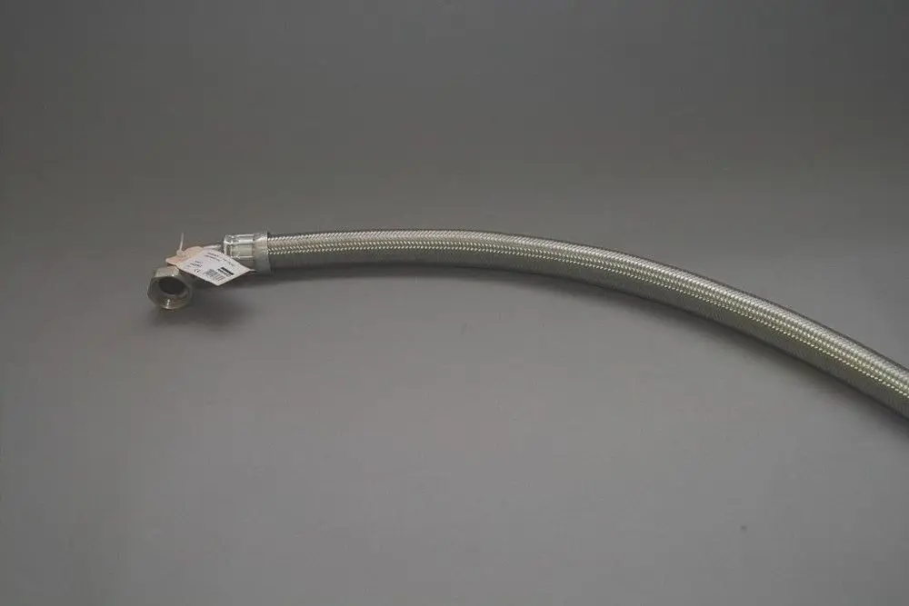 Flexibler Schlauch mit Metallummantelung und einer Verbindungsmutter, gekennzeichnet für Brötje Produkte. Überwiegend schräg liegend auf grauem Hintergrund.