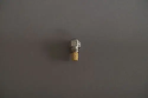 Brötje Düse aus Metall mit einem goldfarbenen Netzfilter, auf grauem Hintergrund. Die Düse hat eine runde Form und Gewinde.