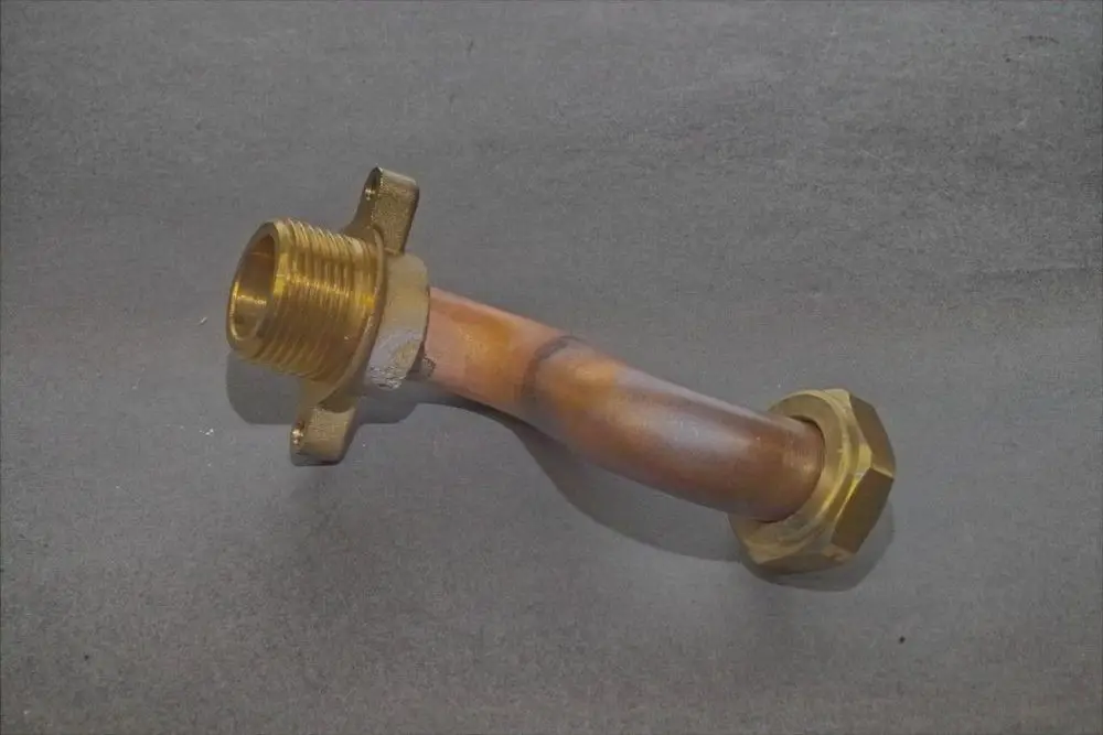 Brötje Anschlussrohr in gebogener Form mit einem Außengewinde und einer Montagefläche zur Befestigung. Das Material wirkt metallisch und ist farblich gemischt.