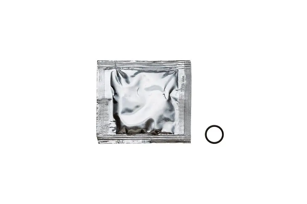Eine silberne Verpackung mit einem schwarzen O-Ring daneben. Die Verpackung könnte ein Produkt von Brötje enthalten, das für technische Anwendungen verwendet wird.