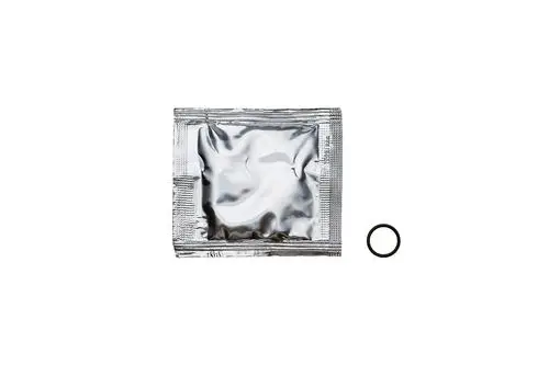 Eine silberne Verpackung mit einem schwarzen O-Ring daneben. Die Verpackung könnte ein Produkt von Brötje enthalten, das für technische Anwendungen verwendet wird.