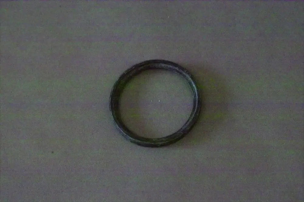 Ring aus metallischem Material, möglicherweise Teil einer Dichtung oder eines Reinigungsölsystems, auf einem neutralen Hintergrund. Marke: Brötje.
