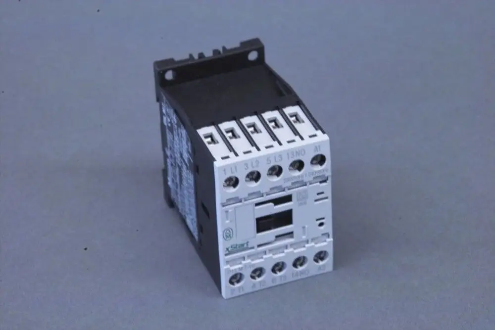 Brötje Schütz, ein elektrisches Steuergerät mit mehreren Anschlussklemmen, montiert auf einer Trägerschiene, auf grauem Hintergrund.