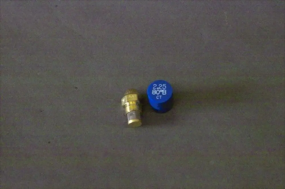 Brötje Düse in Metall mit einer blauen Kappe, die eine Beschriftung aufweist. Die Düse ist auf einem grauen Untergrund abgebildet.