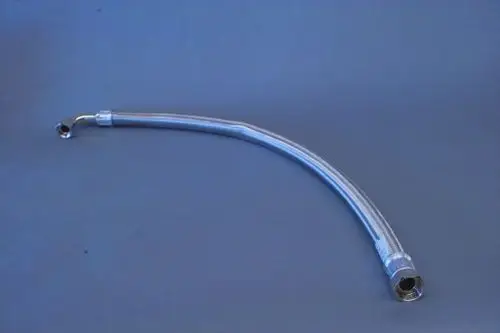 Brötje Panzerschlauch mit metallischem Gewebe, gebogen mit zwei Anschlüssen, einer mit Innengewinde, auf grauem Hintergrund liegend.