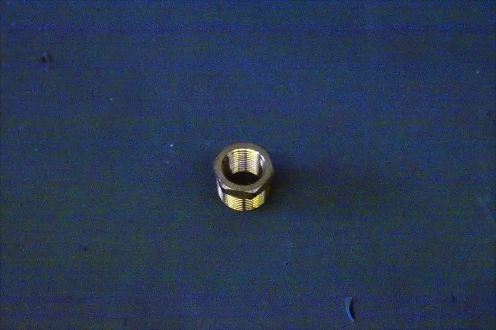 Brötje Reduziernippel aus Metall, mit Innen- und Außengewinde, auf einem blauen Hintergrund. Die Verbindungselemente sind zur Reduzierung von Rohrleitungen geeignet.