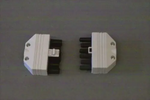 Zwei weiße Brötje Buchsen/Stecker mit jeweils sechs schwarzen Pins, auf grauem Hintergrund angeordnet.