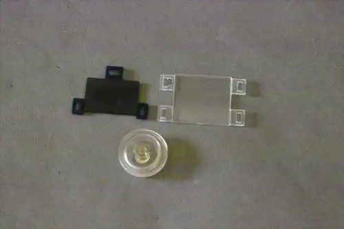 Transparente und schwarze Bauteile von Brötje, bestehend aus einem runden Element und zwei flachen Teilen mit Verbindungsteilen.