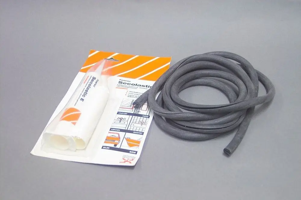 Schwarzes, flexibles Dichtungsband und eine Tube mit Dichtmasse der Marke Brötje, verpackt in einem durchsichtigen Kunststoffbeutel mit grafischen Anweisungen.