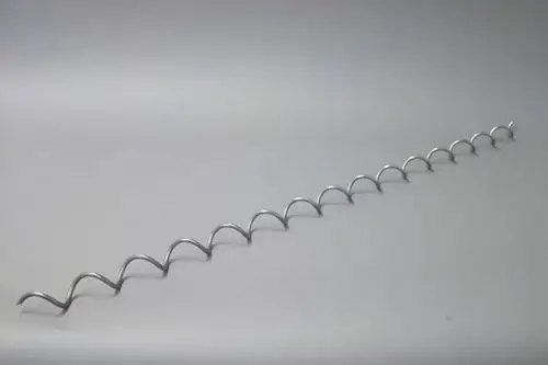 Brötje Wirbulator, metallische Spirale mit gleichmäßigen Wellen, auf heller Oberfläche liegend. Klare Struktur, keine sichtbaren Maße.
