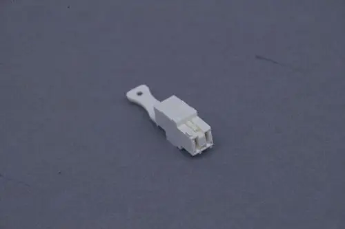 Weiße elektrische Buchse von Brötje, mit zwei Kontaktelementen, auf grauem Hintergrund dargestellt.