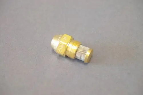 Brassdüse von Brötje mit konischer Form und einem Netzfilter, auf grauem Hintergrund liegend. Ideal für Anwendungen in Heizsystemen.