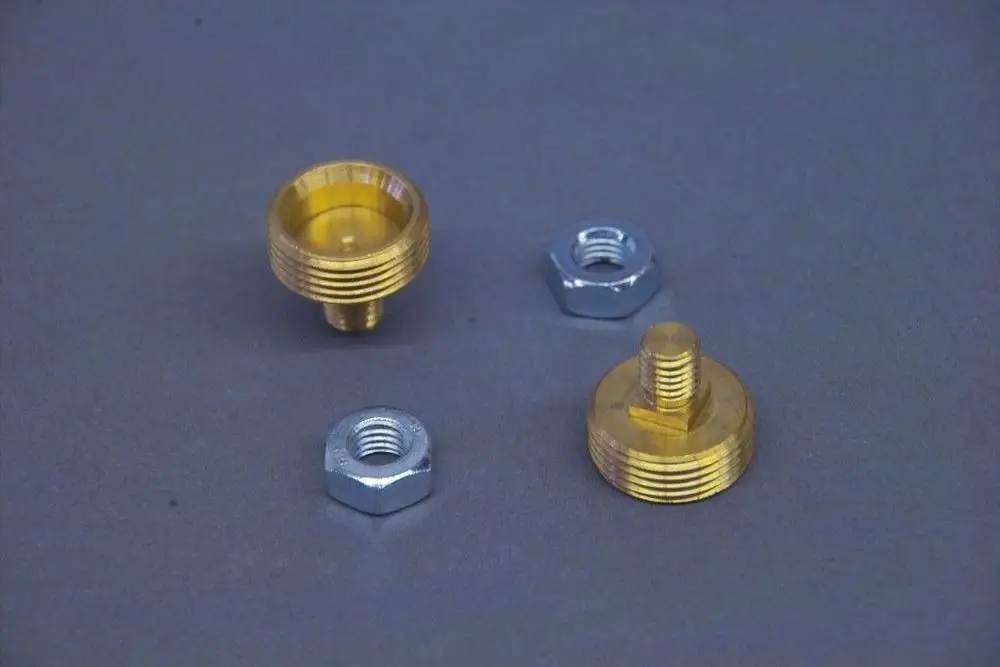 Brötje Anschlussnippel, ein Set bestehend aus zwei metallischen Verbindungsstücken, eines mit einem gerändelten Rand und einem durchgehenden Gewinde, sowie einer Mutter.