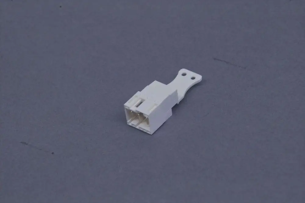 Weißer Stecker mit einer Halterung, hergestellt von Brötje. Das Produkt hat eine kompakte Form und mehrere Anschlüsse auf einer Seite.