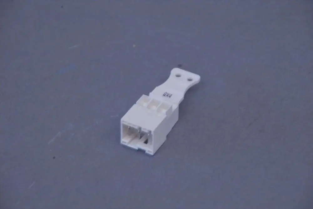 Weißer Stecker mit einer Vorrichtung zur Verbindung, hergestellt von Brötje. Er hat eine kompakte Form und ist auf grauem Hintergrund abgebildet.
