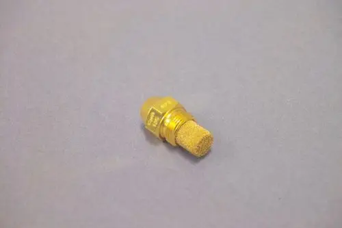 Goldfarbener, zylindrischer Düse von Brötje mit einem schaumstoffartigen Filter an der Spitze, auf einer grauen Unterlage platziert.