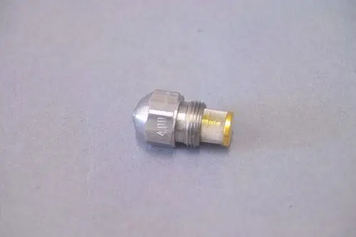 Brötje Düse aus Metall, mit konischer Spitze und einem Gewinde, liegend auf grauem Hintergrund.