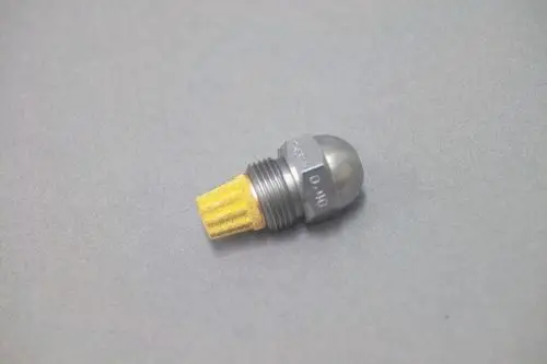Brötje Düse mit einer Metalloberfläche und einem gelben Filterelement, im kompakten Design, auf grauem Hintergrund.
