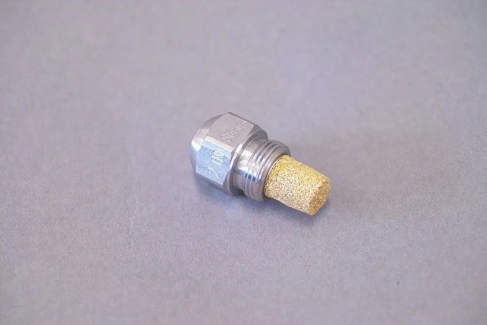 Brötje Düse mit hexagonalem Kopf und porösem Einsatz aus Beige. Geeignet für präzise Flüssigkeitsdosierung in Heizsystemen.