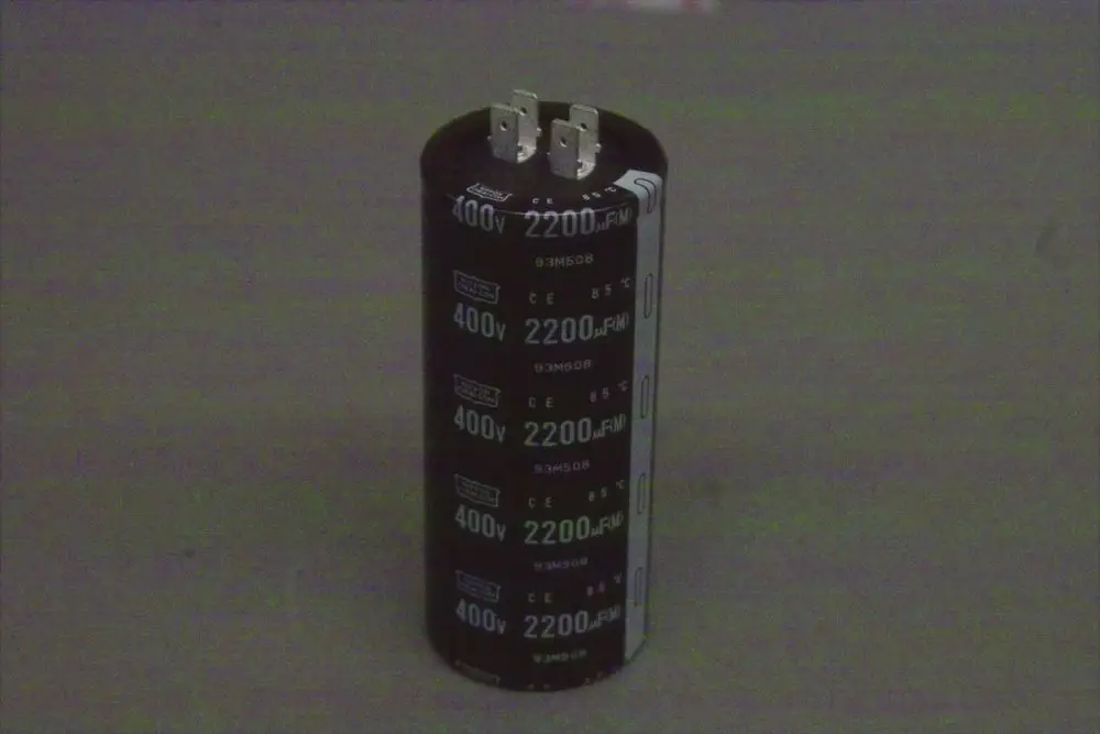 Schwarzer Elektrolytkondensator von Brötje mit zwei Anschlussbeinchen, Beschriftung für Spannung von 400V und Kapazität von 2200μF, zylindrische Form.