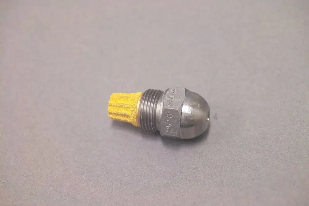 Brötje Düse aus Metall mit einer gelben Borstenstruktur an einem Ende. Das Metallteil hat eine abgerundete, glänzende Spitze und ein Gewinde auf der anderen Seite.