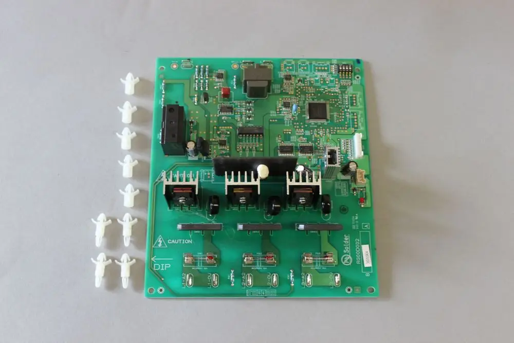 Brötje Platine mit mehreren elektronischen Komponenten, darunter Stecker, Widerstände und Kühlkörper, umgeben von kleinen weißen Bauteilen.