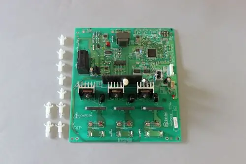 Brötje Platine mit mehreren elektronischen Komponenten, darunter Stecker, Widerstände und Kühlkörper, umgeben von kleinen weißen Bauteilen.