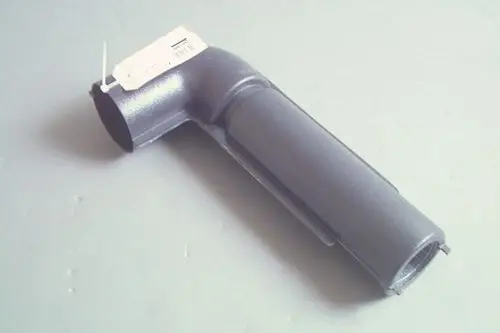Grauer Ansaugschalldämpfer mit gebogenem Ende und einer offenen Seite, erkennbar als Produkt von Brötje, auf grauem Hintergrund.