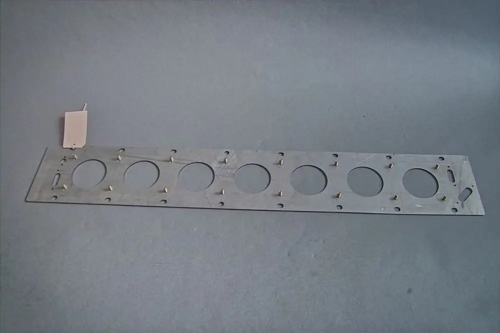 Eingebranntes Metallblech mit mehreren runden Ausschnitten und feststehenden Stiften, typisches Bauteil von Brötje.