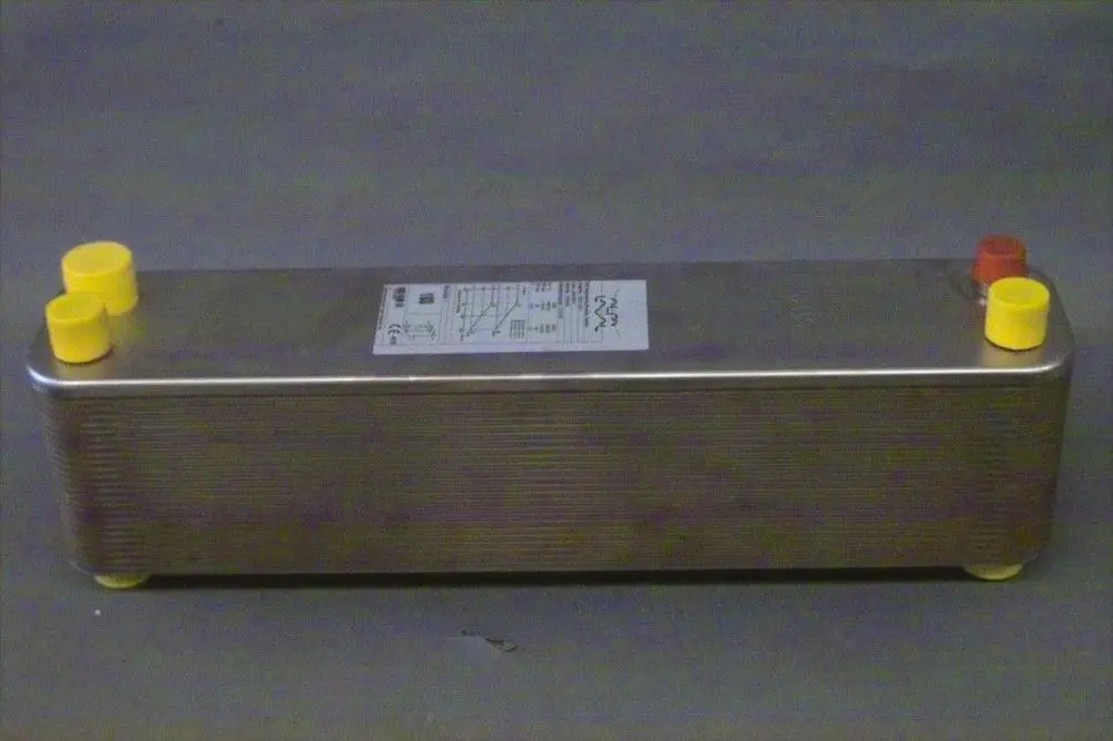 Brötje Verdampfer mit schwarzem Gehäuse und gelben sowie roten Anschlüssen. Auf der Oberfläche befindet sich ein Typenschild mit technischen Informationen.