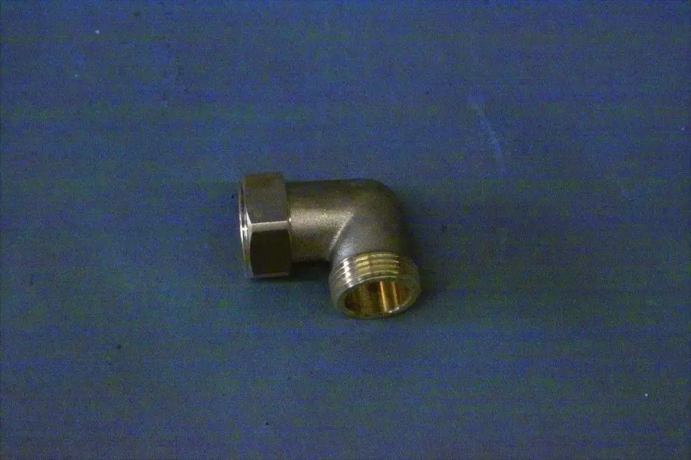 Brötje Winkel aus Metall mit einem 90-Grad-Biegung und zwei unterschiedlichen Anschlussgewinden, liegend auf einer blauen Unterlage.