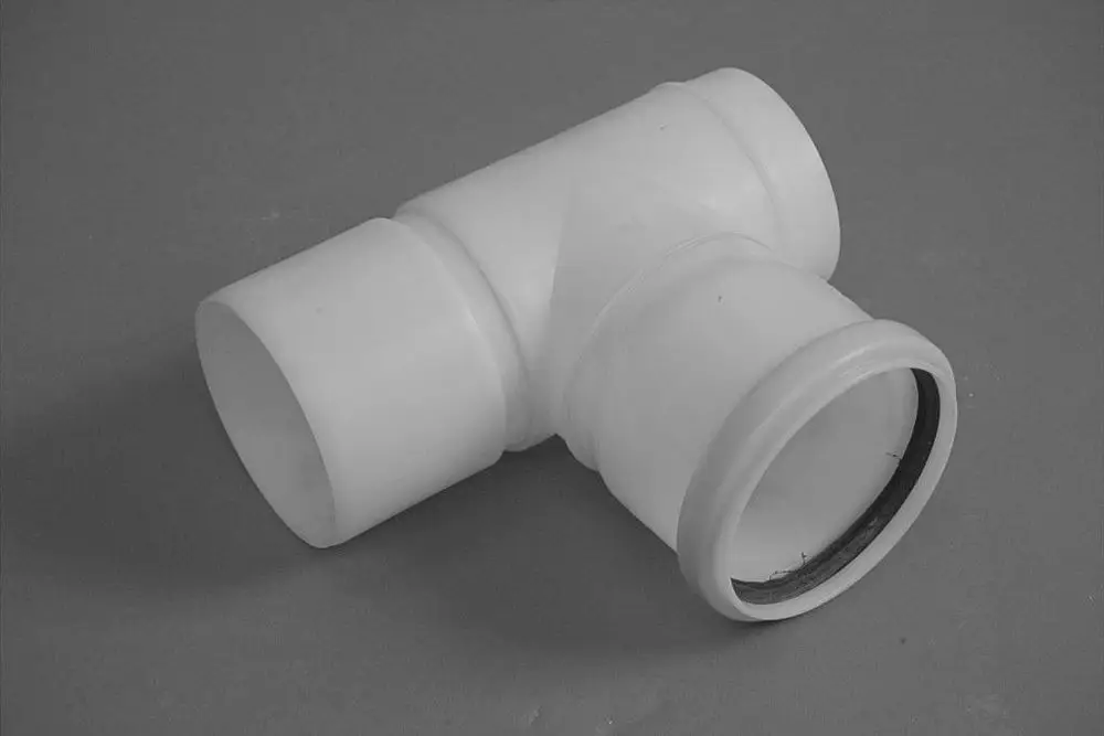 Weißes Kunststoff-Rohrstück mit drei Anschlüssen, das als Rückströmsicherung fungiert. Typisches Produkt von Brötje zur Anwendung in Heizungs- oder Sanitärinstallationen.