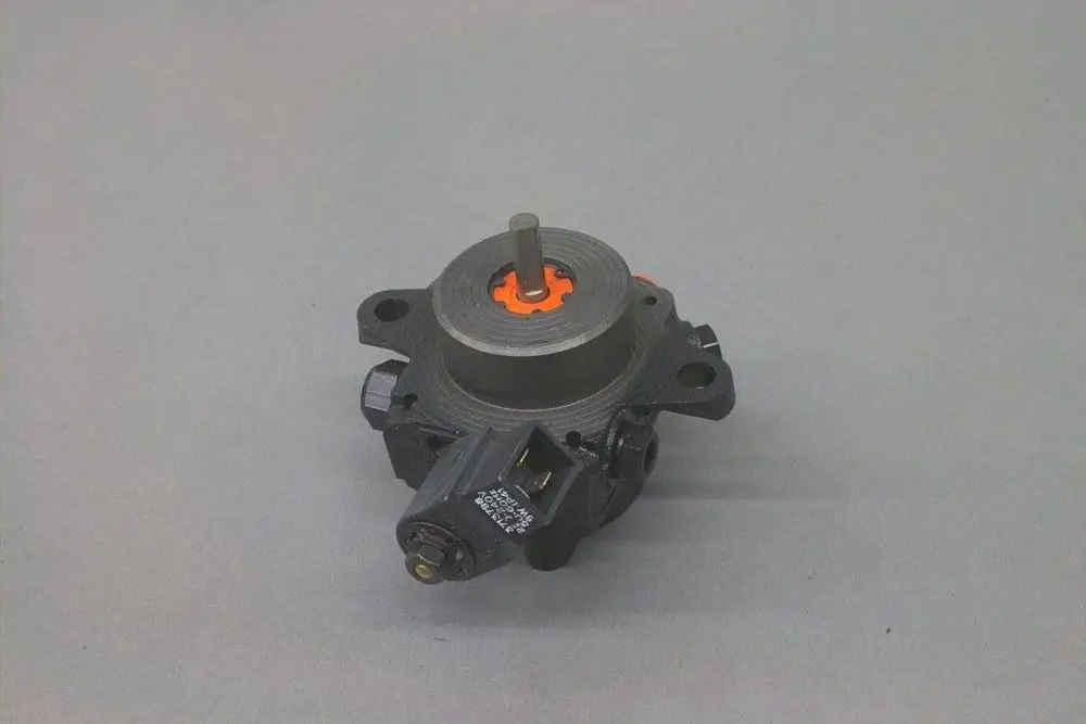 Brötje Pumpe mit zentraler Achse und seitlichem Anschluss. Die Oberflächenstruktur ist glatt, und die Anschlussstelle zeigt elektrische Komponenten.
