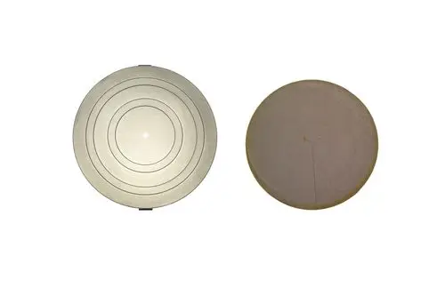 Zwei runde Isolierdeckel, einer mit konzentrischen Linien und der andere glatt, möglicherweise für Brötje Geräte, vor neutralem Hintergrund.