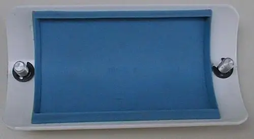 Reinigungstür mit blauer Gummidichtung und zwei Rändelschrauben, montiert auf einer weißen Oberfläche, zugehörig zu Brötje-Produkten für Heizsysteme.