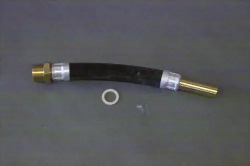 Brötje Rücklaufrohr aus schwarzem Schlauch mit goldfarbenen und weißen Verbindungsteilen, begleitet von einem weißen O-Ring auf grauem Hintergrund.