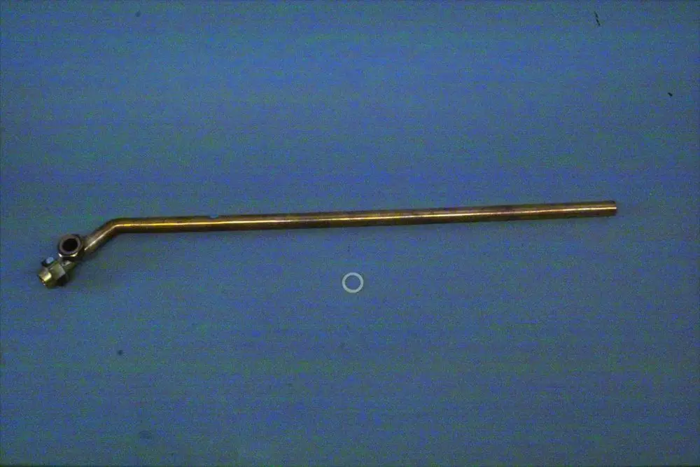 Röhrenförmiges Rücklaufrohr von Brötje mit einer geknickten Stelle und einer Anschlussmuffe auf einer blauen Unterlage.