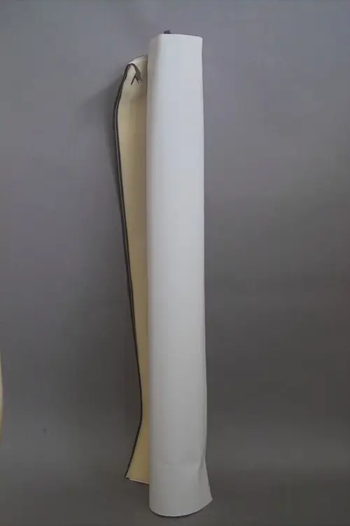 Brötje Verkleidungsmantel, helles Material, aufgerollt und teilweise aufgeklappt, vor grauem Hintergrund.