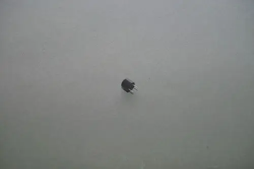 Schwarze Sicherung mit drei Anschlussstiften auf grauem Hintergrund. Die Marke Brötje ist deutlich erkennbar.