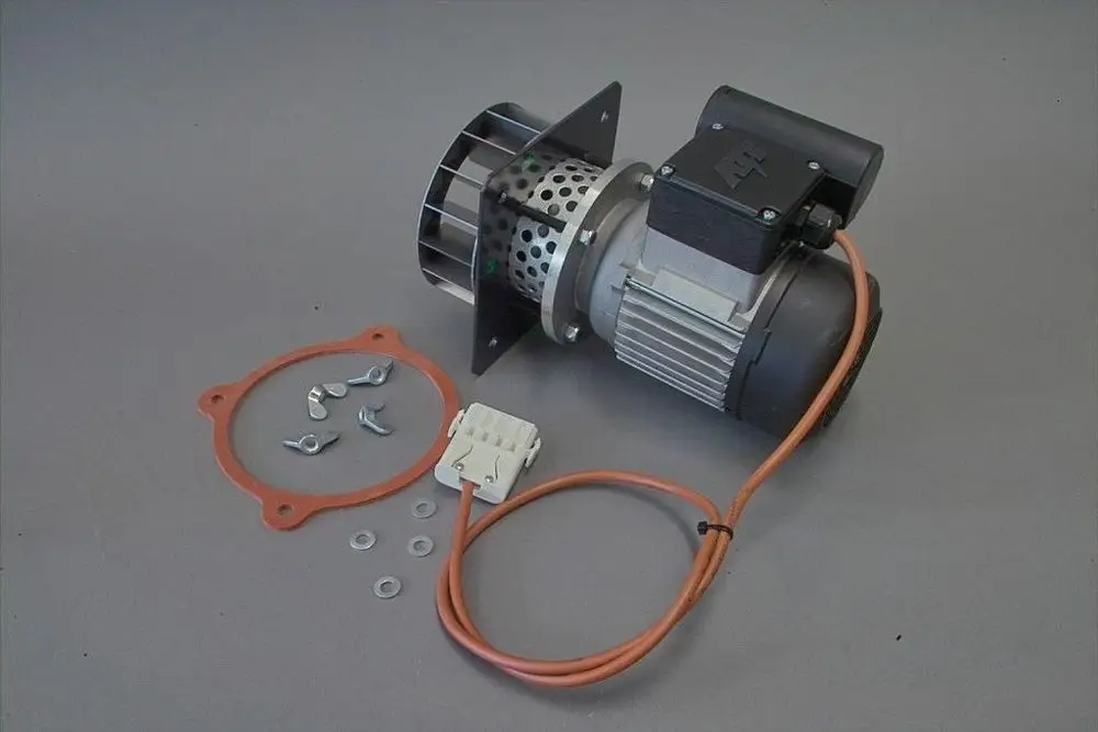 Brötje Lüftermotor mit montierter Frontplatte, Kabel und Zubehörteilen wie Dichtungen, Schrauben und Unterlegscheiben auf grauem Hintergrund.