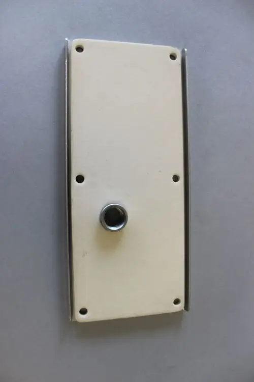 Brötje Reinigungsdeckel mit Dichtung, rechteckige Form, Montagebohrungen an den Ecken, zentraler Einschub für Anschluss.