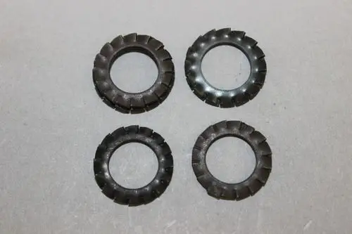 Vier schwarze Zahnscheiben mit zähniger Oberfläche, geeignet für verschiedene Anwendungen. Sichtbar sind zwei unterschiedliche Designs. Erzeugt von der Marke Brötje.